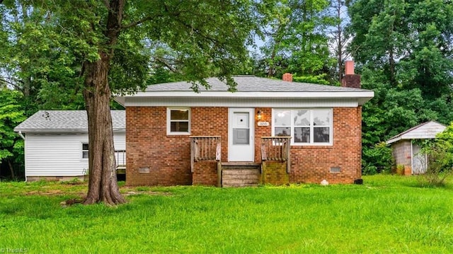 1655 Oakleigh Rd, Mcleansville, NC 27301 - bungalow-style house featuring a chimney, brick siding, crawl space, a front lawn, and an outdoor structure