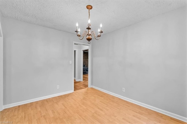 1655 Oakleigh Rd, Mcleansville, NC 27301 - empty room with a chandelier, light wood-type flooring, and a textured ceiling