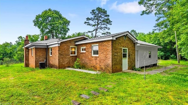 1655 Oakleigh Rd, Mcleansville, NC 27301 - back of house with a chimney, a yard, and brick siding