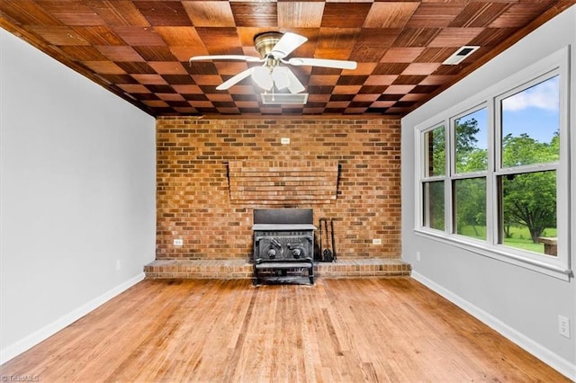 1655 Oakleigh Rd, Mcleansville, NC 27301 - unfurnished living room with a wood stove, wood finished floors, and a ceiling fan