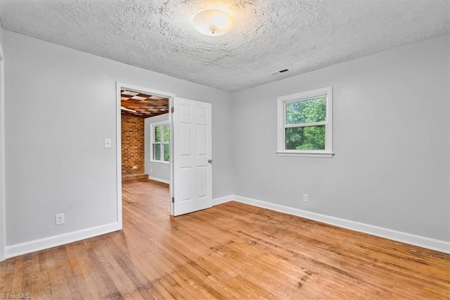 1655 Oakleigh Rd, Mcleansville, NC 27301 - spare room with light wood-style floors, plenty of natural light, and a textured ceiling