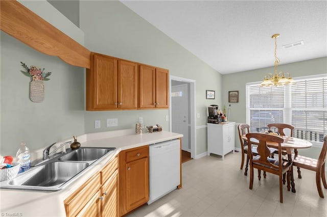 kitchen featuring dishwasher, sink, pendant lighting, a chandelier, and lofted ceiling