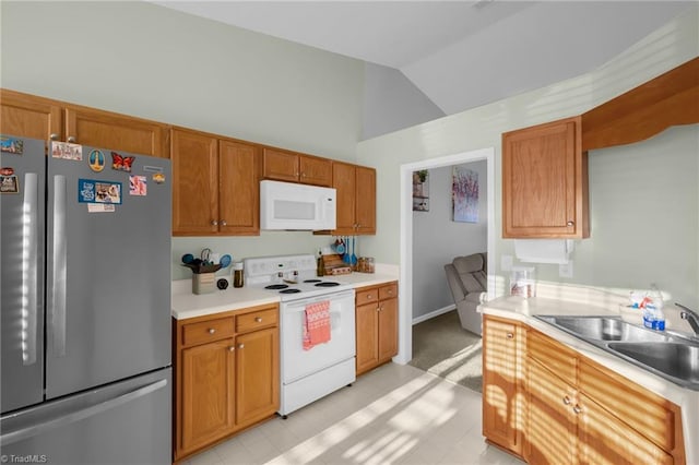 kitchen with white appliances, sink, and vaulted ceiling