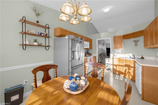 dining space with light tile patterned floors, vaulted ceiling, a notable chandelier, and sink