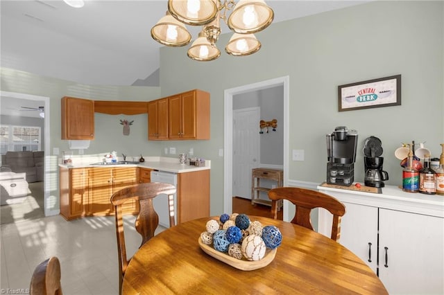 dining space with sink and ceiling fan with notable chandelier