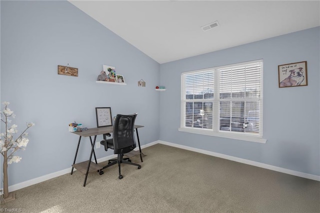 carpeted home office with vaulted ceiling