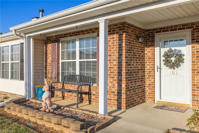 view of exterior entry featuring covered porch