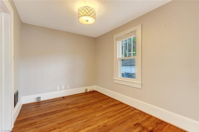 unfurnished room with hardwood / wood-style flooring