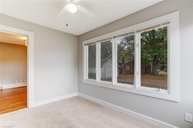 empty room with light colored carpet and ceiling fan