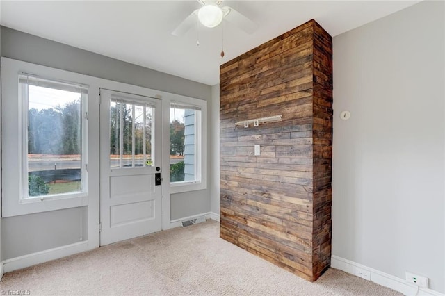 doorway featuring ceiling fan, a healthy amount of sunlight, and light colored carpet