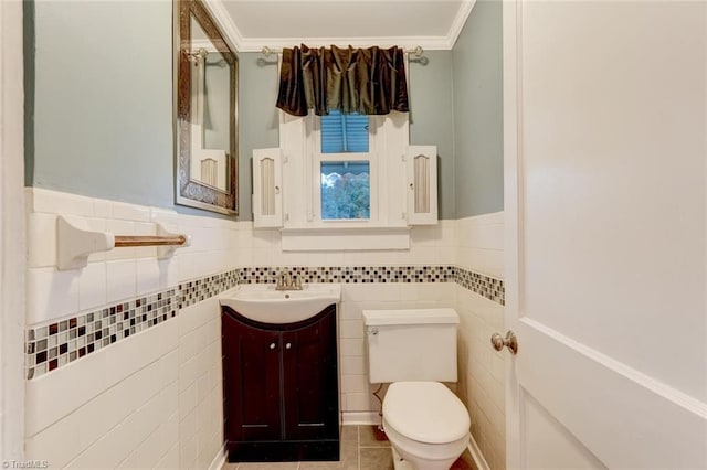 bathroom with vanity, toilet, tile walls, and ornamental molding