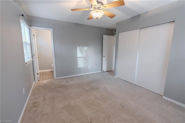 unfurnished bedroom with ensuite bathroom, light colored carpet, ceiling fan, and a closet