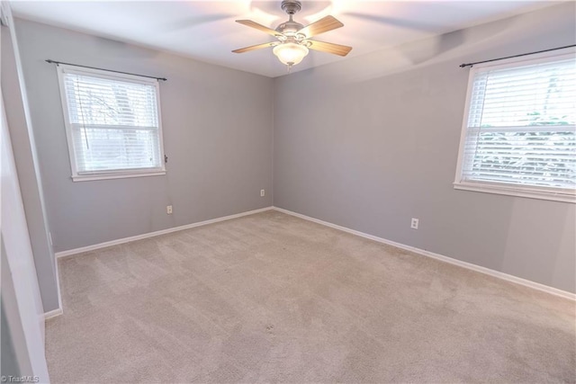 carpeted empty room featuring a healthy amount of sunlight and ceiling fan