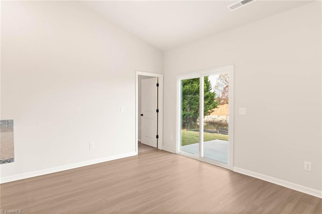 unfurnished room with light hardwood / wood-style floors and vaulted ceiling