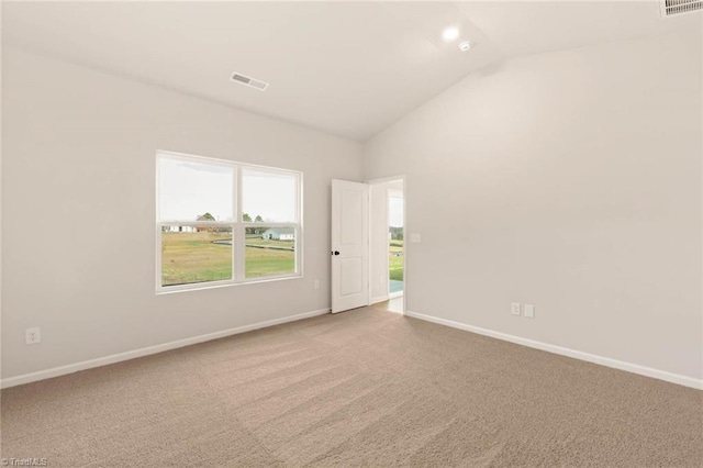 spare room featuring carpet floors and vaulted ceiling