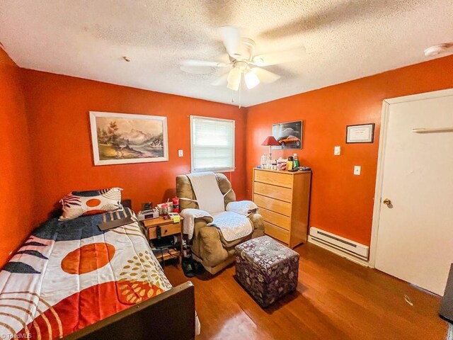 2778 Reynolds Park Rd, Winston-Salem, NC 27107 - bedroom with ceiling fan, a baseboard heating unit, wood finished floors, and a textured ceiling