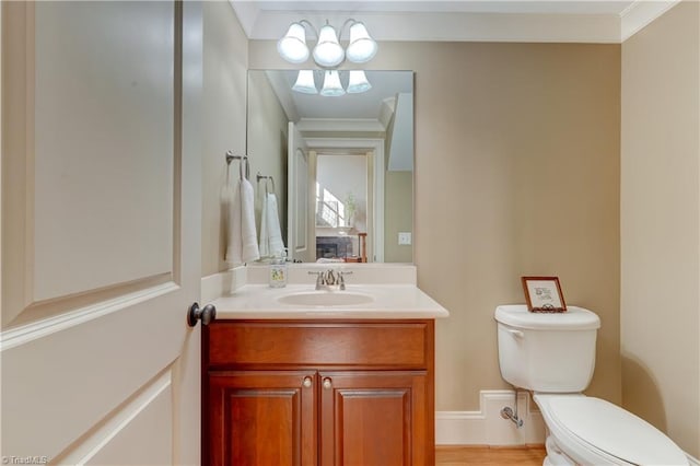 bathroom with vanity, ornamental molding, toilet, and hardwood / wood-style floors