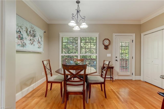 dining area featuring ornamental molding, hardwood / wood-style floors, and an inviting chandelier