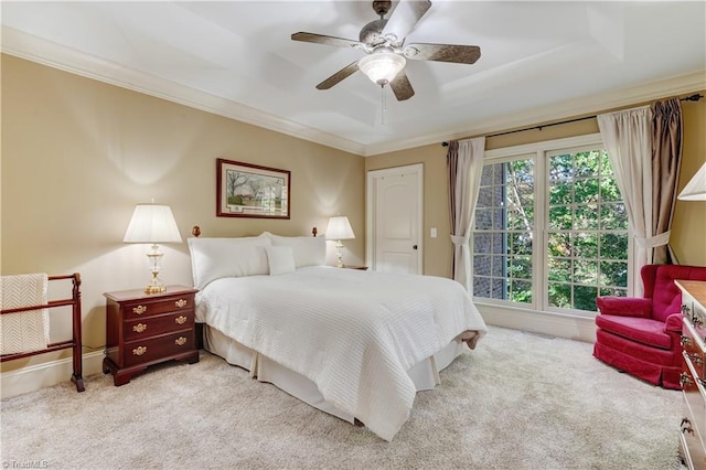 bedroom with ornamental molding, light colored carpet, a raised ceiling, and ceiling fan