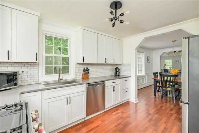 1229 Martin St, Winston-Salem, NC 27103 - kitchen featuring appliances with stainless steel finishes, ornamental molding, a sink, arched walkways, and tasteful backsplash