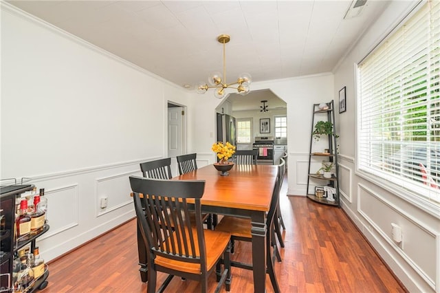 1229 Martin St, Winston-Salem, NC 27103 - dining area featuring ornamental molding, wood finished floors, a decorative wall, a chandelier, and wainscoting