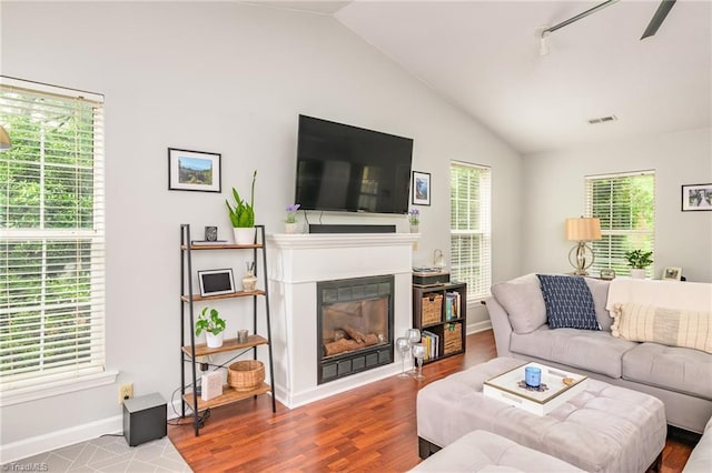 1229 Martin St, Winston-Salem, NC 27103 - living area featuring a glass covered fireplace, vaulted ceiling, baseboards, and wood finished floors