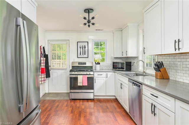 1229 Martin St, Winston-Salem, NC 27103 - kitchen featuring stainless steel appliances, a sink, tasteful backsplash, dark wood-style flooring, and white cabinetry
