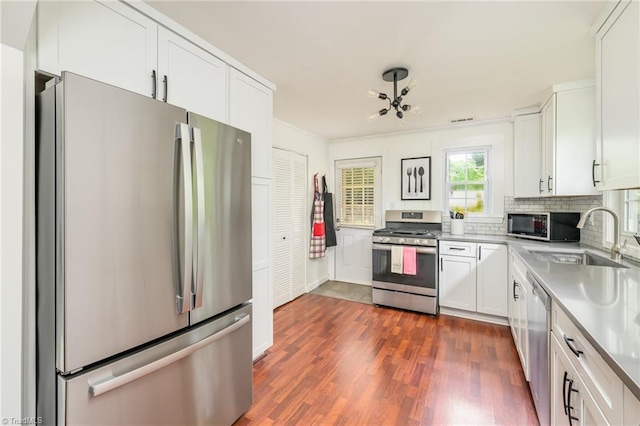1229 Martin St, Winston-Salem, NC 27103 - kitchen with appliances with stainless steel finishes, a sink, white cabinetry, dark wood finished floors, and light countertops