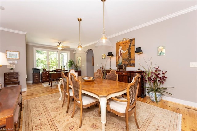 dining space with crown molding, ceiling fan, and light hardwood / wood-style flooring