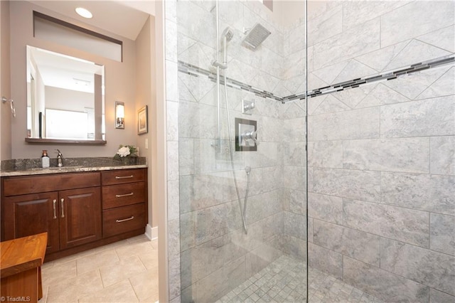 bathroom with vanity, a tile shower, and tile patterned floors