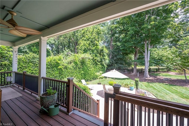 deck featuring ceiling fan and a lawn