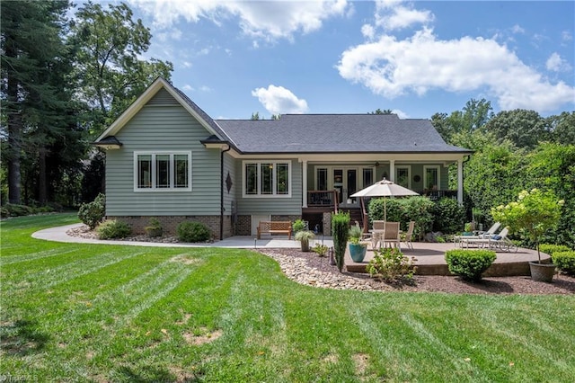 rear view of house featuring a yard and a patio area