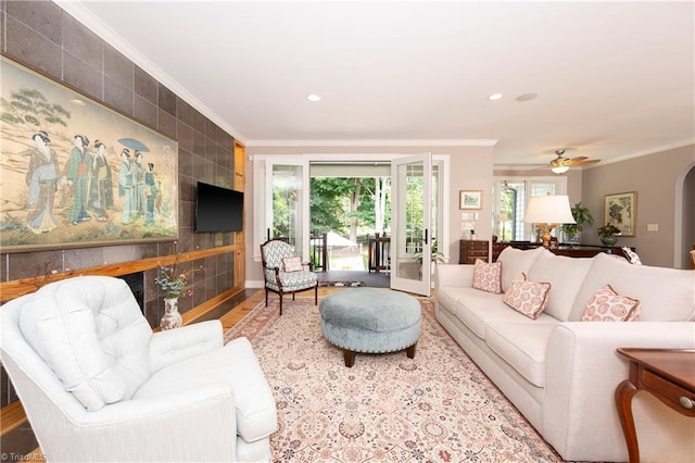 living room with hardwood / wood-style flooring, ornamental molding, and ceiling fan