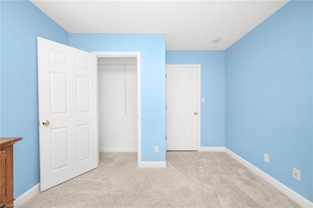 unfurnished bedroom featuring a closet and light colored carpet