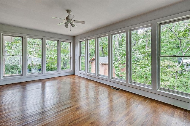 unfurnished sunroom with ceiling fan and a healthy amount of sunlight