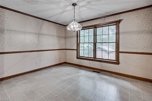 spare room featuring a textured ceiling, crown molding, and a chandelier