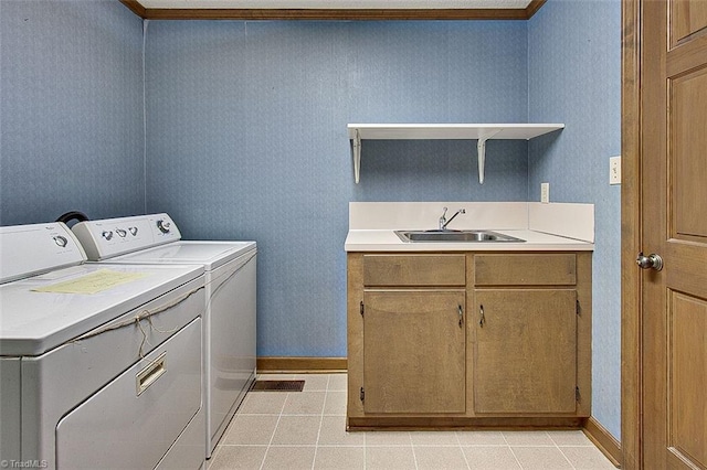 clothes washing area with light tile patterned flooring, ornamental molding, sink, and independent washer and dryer