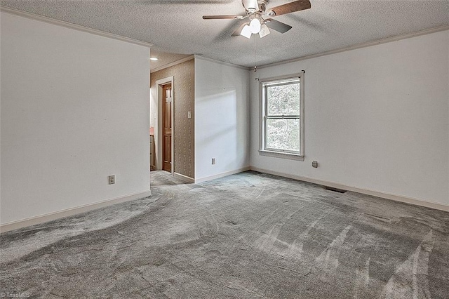 carpeted empty room featuring ornamental molding, a textured ceiling, and ceiling fan