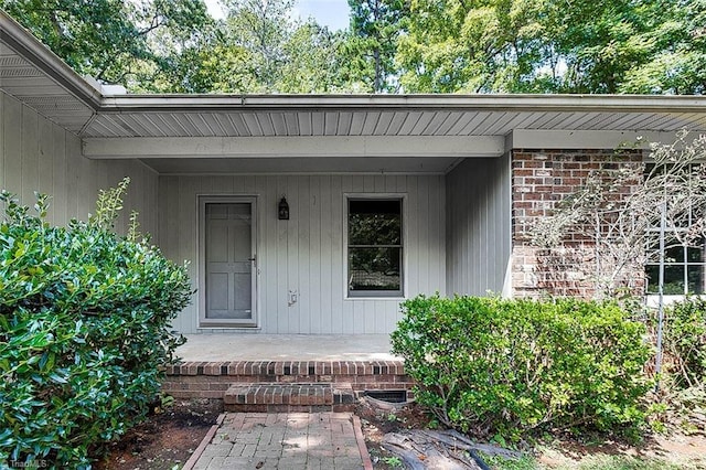 view of exterior entry featuring covered porch