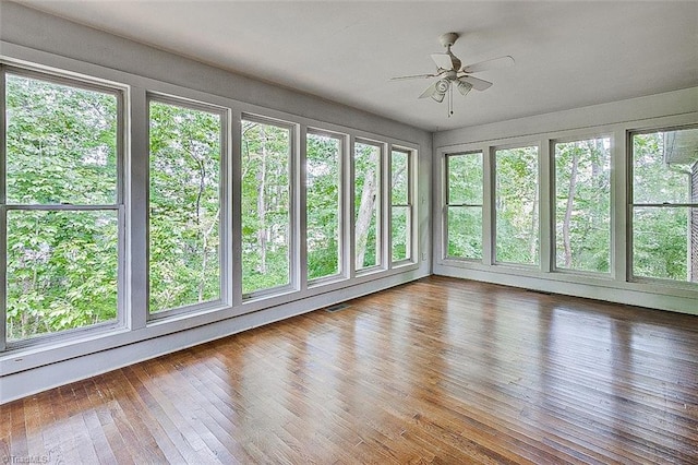 unfurnished sunroom with ceiling fan and plenty of natural light