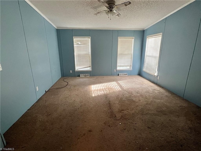 unfurnished room with carpet, a textured ceiling, ceiling fan, and crown molding