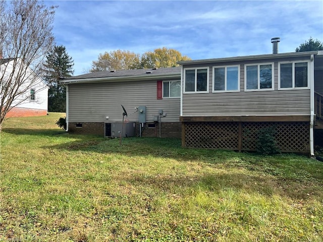 back of property with a yard and a sunroom