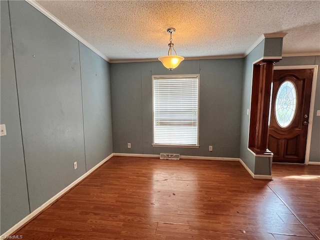 interior space with hardwood / wood-style floors, a textured ceiling, and crown molding