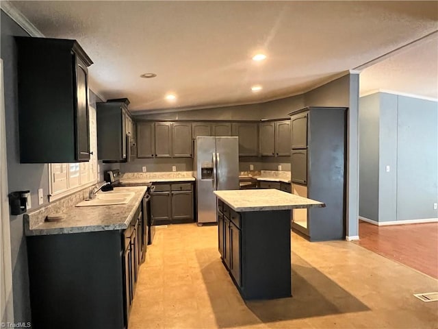 kitchen featuring a kitchen island, ornamental molding, stainless steel appliances, and vaulted ceiling