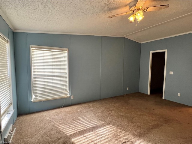 carpeted empty room featuring ceiling fan, crown molding, and a textured ceiling