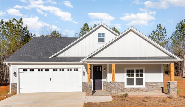 view of front of property with driveway, a porch, an attached garage, stone siding, and board and batten siding