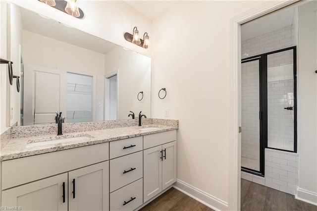 full bathroom with a shower stall, wood finished floors, and a sink