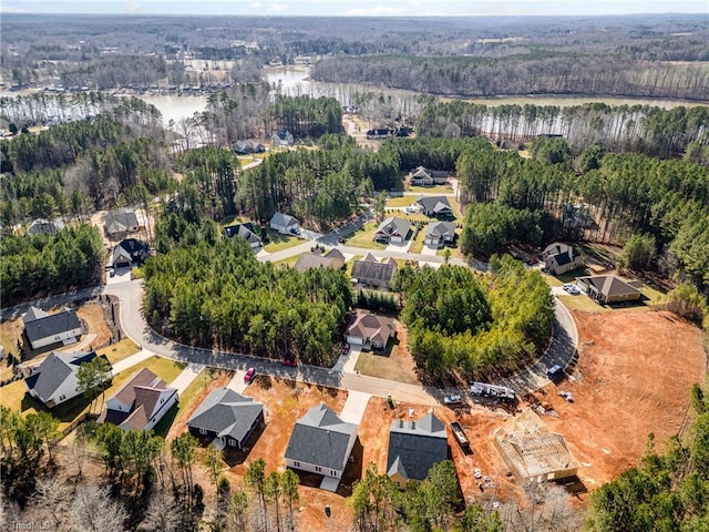 bird's eye view featuring a residential view, a water view, and a wooded view