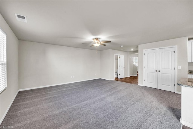 unfurnished room featuring visible vents, baseboards, a ceiling fan, and dark colored carpet