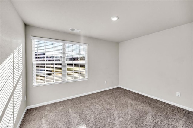 unfurnished room with visible vents, carpet, and baseboards